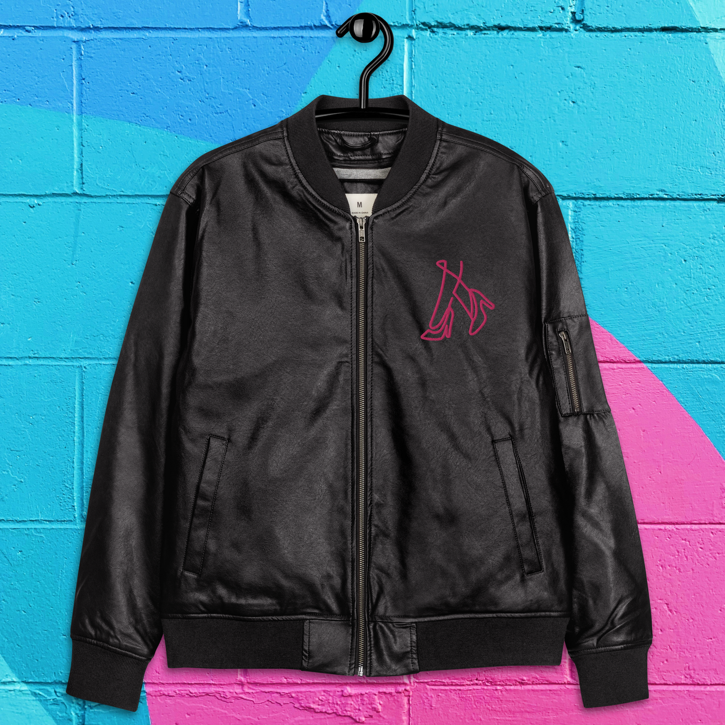 Chaqueta bomber de cuero negro y rosa caliente para mujer.