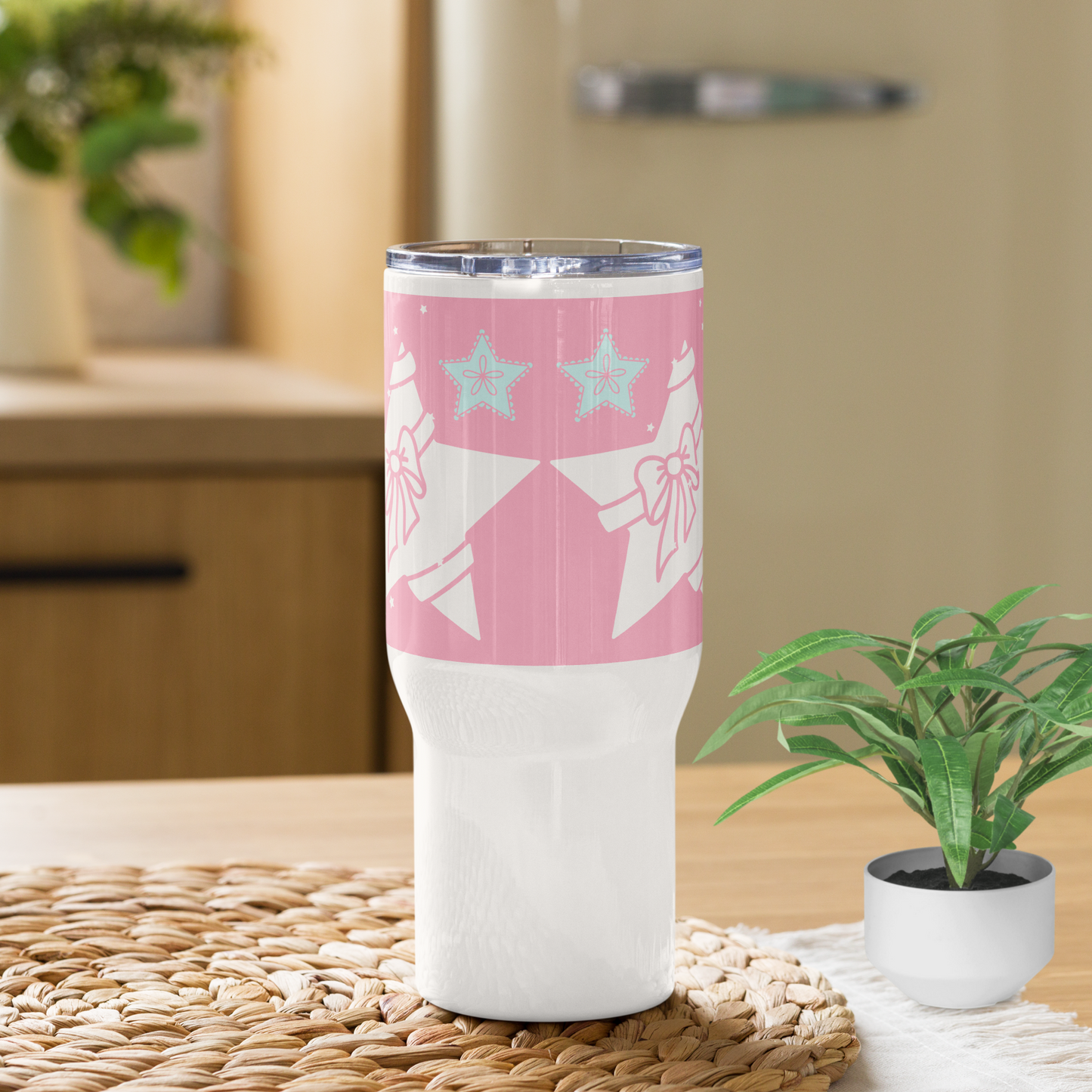 Pink and white travel mug with a handle.